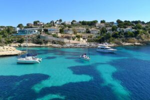 Villen an der Küsten von Mallorca, im Wasser fahren Boote und Yachten