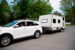 Family getting ready to leave for summer vacations with RV. Car on the street, house in the background. Horizontal full length outdoors shot with copy space.